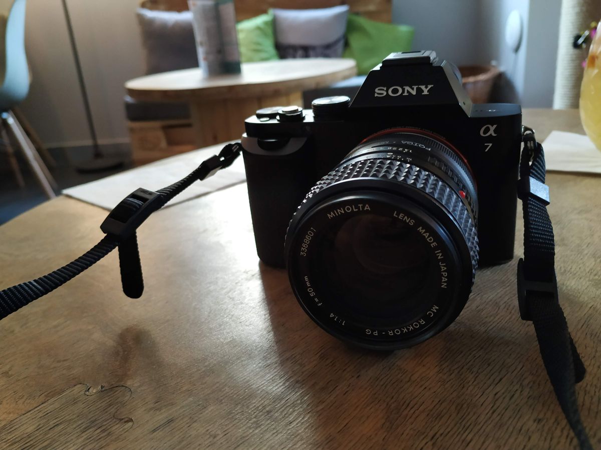 Aparat Sony Alpha 7 z obiektywem Minolta na drewnianym stole